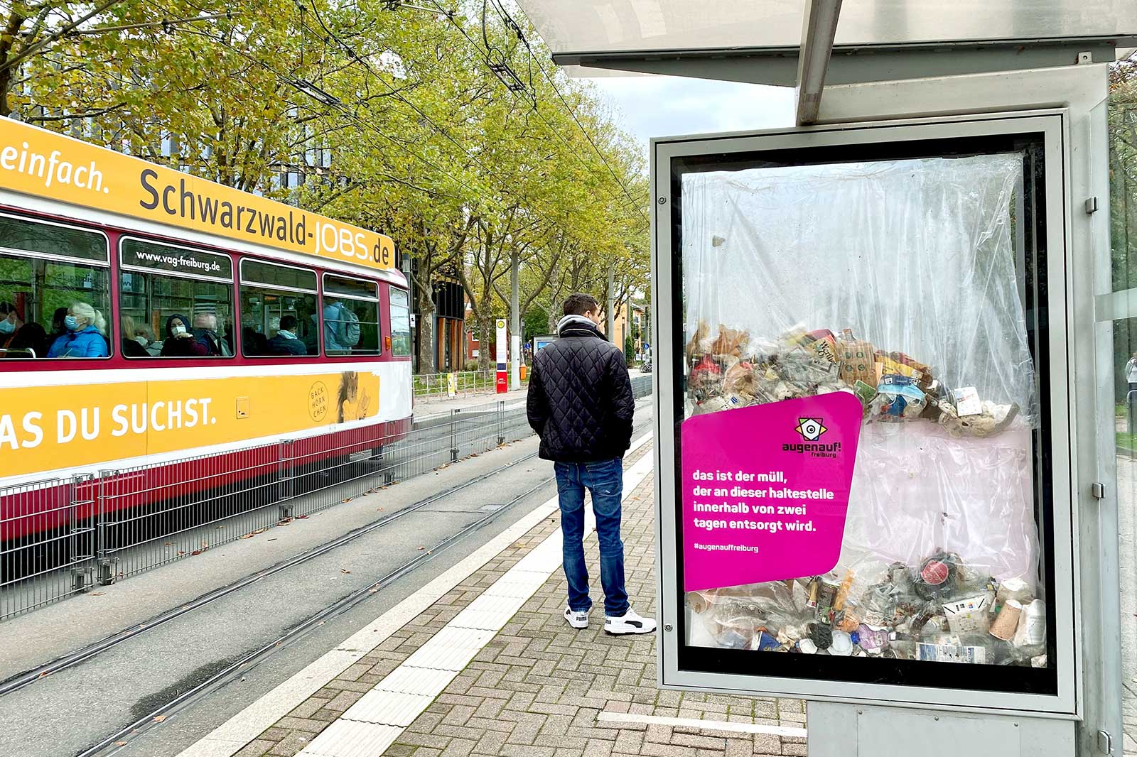 Plakat der Kampagne augenauf! freiburg an einer Straßenbahn-Haltestelle in Freiburg