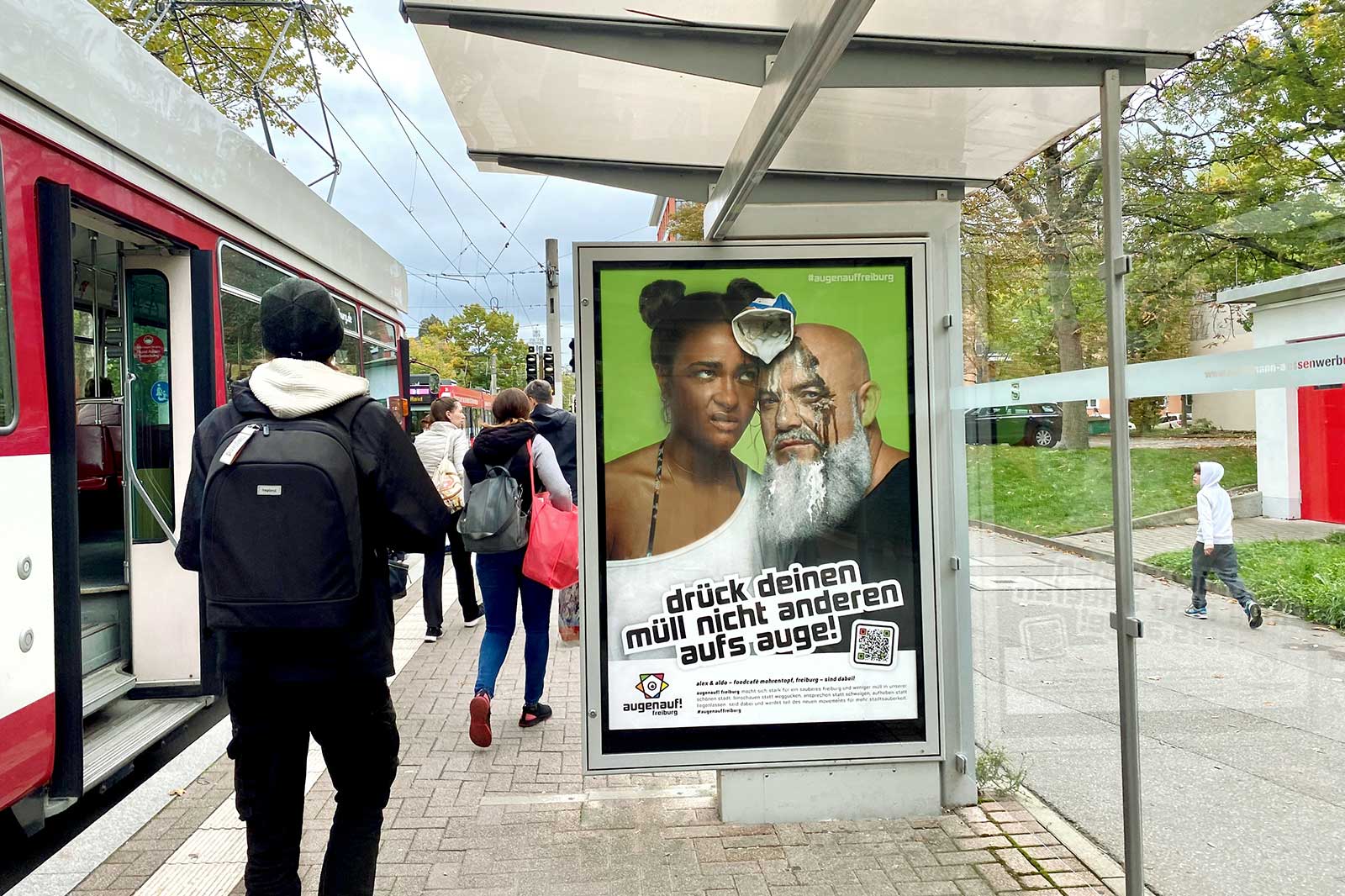 Plakatmotiv der Kampagne #augenauffreiburg an einer Straßenbahn-Fahrgastunterstand in Freiburg