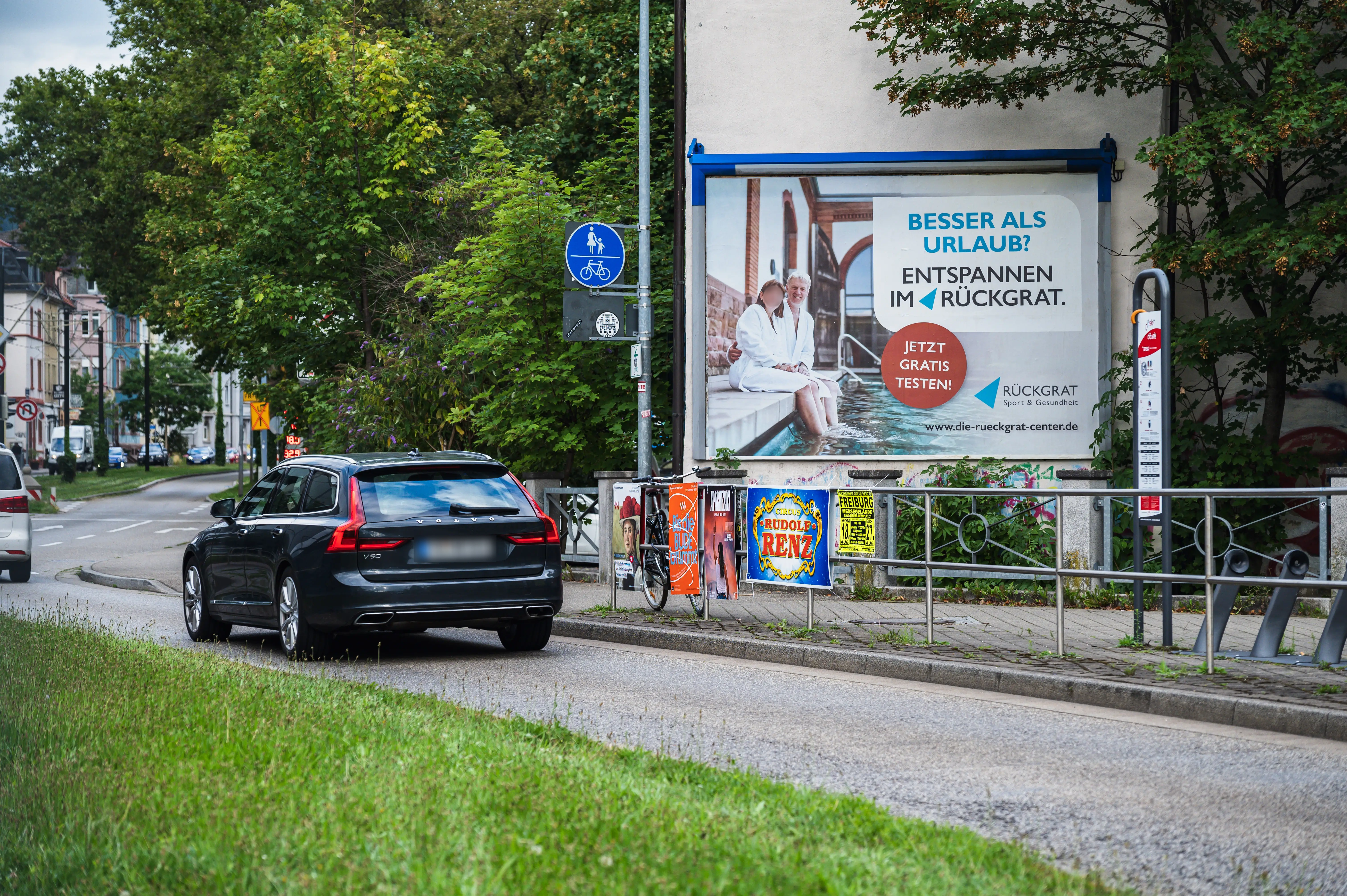 Werbung für „Rückgrat – Sport & Gesundheit“ auf 18/1-Plakat an Hauswand an der Straße